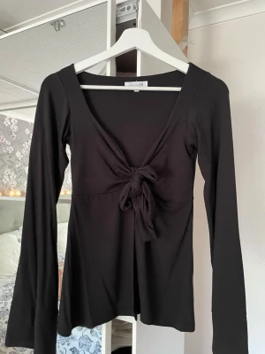 Svart långärmad topp med knyt från designbysi  - Säljer nu min topp från designbysi då jag inte får användning av den längre😊har använt den max 3 gånger så därför är den i bra skick💕