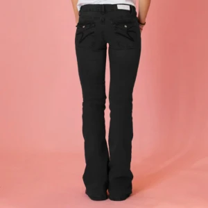 Low waist bootcut jeans - Snygga svarta jeans från din vintage shop med bootcut passform och låg midja. Jeansen har klassiska fem fickor, coola detaljer på bakfickorna och är tillverkade i mjukt jeansmaterial med lite stretch🩷🩷som är lite sönder på lappen i bak som i bilden