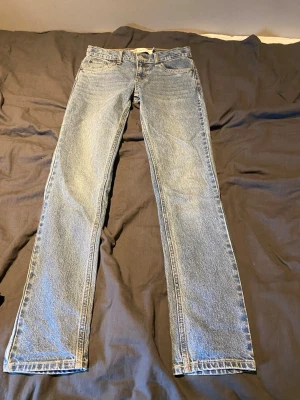 Levi's 512 Slim Taper jeans blå - Säljer ett par klassiska Levi's 512 Slim Taper jeans i ljusblå denim. Jeansen har fem fickor, bälteshällor och knappgylf. Modellen är smal med avsmalnande ben och passar perfekt till en avslappnad stil. Materialet är slitstark bomullsdenim.