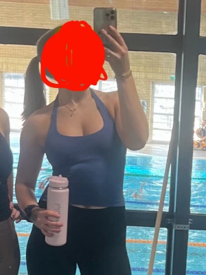 Blå halterneck sportlinne GTECH - Snyggt blått sportlinne från GTECH med halterneck och tight passform. Perfekt för gymmet eller träning, tillverkat i stretchigt funktionsmaterial som andas. Logga framtill i vitt. Ger en sportig och modern look.