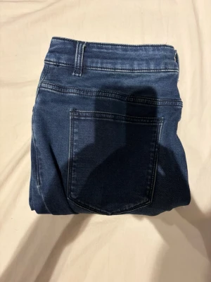 McKenzie jeans  - Snygga mörkblå jeans med klassisk femficksdesign och raka ben. Jeansen har tydliga sömmar och bälteshällor i midjan. Materialet är denim som ger en tidlös look och passar till många olika stilar.