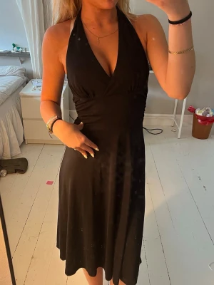 Svart halterneckklänning - Supersnygg svart midi klänning med v-rigninh som man knyter i ryggen 🖤