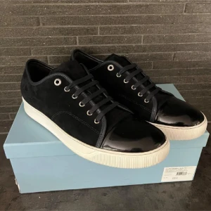 Marine blå lanvin - Snygga marine blå sneakers med vit sula och cool lackad tå. Ovandelen är i mocka och detaljer i skinn. Perfekta för dig som vill ha en stilren men ändå unik look. Storlek Uk 11 passar 45-46