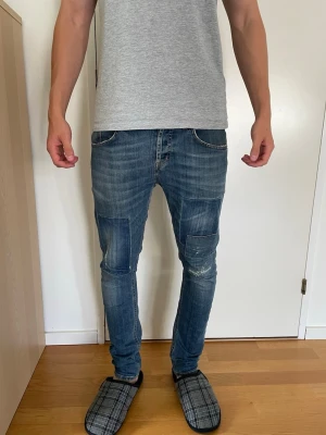 Dondup Mius - Säljer ett par blå Dondup mius slim fit jeans med patchdetaljer på knäna och lätt slitna partier. Jeansen är väl använda och har en skön passform. Köpta begagnat och säljs nu för 250kr. Storlek 30, hör av er vid frågor!