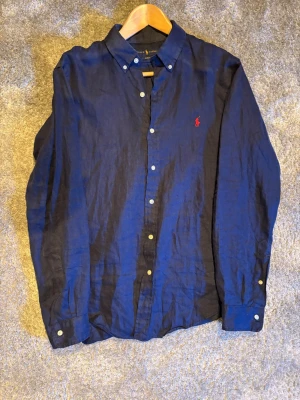 Mörkblå linneskjorta Ralph Lauren - Mörkblå skjorta från Ralph Lauren. Nypris ca 1800kr. Storlek M. Jättebra skick.