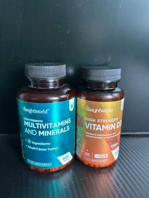 WeightWorld multivitaminer & D3 - Två burkar kosttillskott från WeightWorld: en med multivitaminer och mineraler (27 ingredienser, blå etikett) och en med högdoserad vitamin D3 (4000 IU, orange etikett). Båda burkarna är bruna med svarta lock och innehåller 400 tabletter vardera.