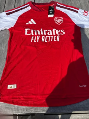 Gyökeres #14 – Hemma Arsenal (storlek M) - Gyökeres #14-tryck. Nya säsongens hemmatröja. Storlek M. Helt ny och aldrig använd. Skickas snabbt 🚚💨  Mått (M): Halvt bröstmått 51 cm • Längd 72,5 cm • Ärmbredd 22,5 cm • Axelbredd 43 cm • Ärmlängd 39 cm • Manschett 18 cm.  🔥 Player Edition – tajtare passform än vanliga supportertröjor.  📩 Skicka gärna ett meddelande vid frågor eller prisförslag! 🛍 Bundle-rabatt upp till 20%! 📦 Skickas samma eller nästa dag.