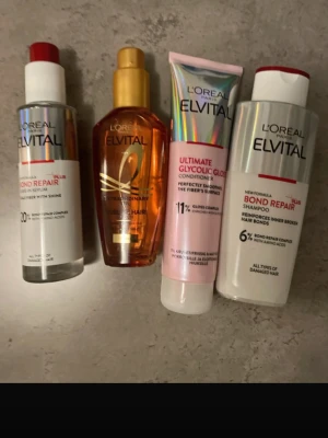 L'Oréal Elvital hårvårdsset - Säljer ett set med fyra L'Oréal Elvital-produkter: Bond Repair serum, Extraordinary Oil, Ultimate Glycolic Gloss balsam och Bond Repair schampo. Produkterna är i olika färger som silver, guld, rosa och vitt och passar för skönhetsrutinen för håret.Elvital Ultimate Glycolic Gloss Balsam (150 ml) – Glansgivande balsam som slätar ut hårfibrerna för ett spegelblankt resultat.  Skick: Helt nytt / OöppnatNypris i butik: ca 450 kr totalt