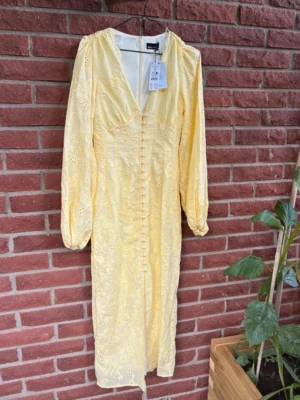 Gul broderad klänning Gina Tricot - Söt gul klänning från Gina Tricot i storlek 36. Klänningen har broderade blommönster, v-ringning, långa puffärmar och knappar framtill. Tillverkad i ett lätt tyg med fodrad insida. Slutsåld populär klänning, 599kr
