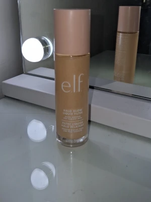 e.l.f. Halo Glow Liquid Filter foundation fair 0 - e.l.f. Halo Glow Liquid Filter foundation i en beige nyans. Kommer i en cylinderformad glasflaska med ljusrosa lock. Ger en glowig finish och kan användas både som foundation eller glow booster. Perfekt för dig som vill ha en naturlig lyster.Färg fair 0💕