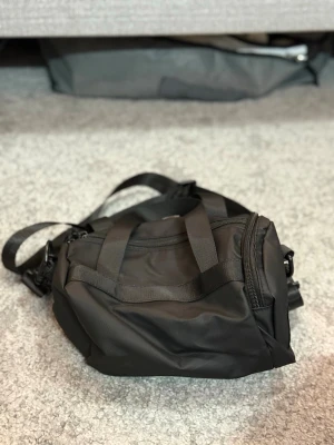 Liten Duffle Bag Svart - Liten och praktisk duffle bag i svart. Perfekt för träning, kortare resor eller som vardagsväska.  Färg: Svart Storlek: NO SIZE  Fraktar inom 24h vid snabb affär. Byten är inte aktuella.  #DuffleBag #Bag #SvartVäska #TravelBag #StreetwearLiten och praktisk duffle bag i svart. Perfekt för träning, kortare resor eller som vardagsväska.  Färg: Svart Storlek: NO SIZE  Fraktar inom 24h vid snabb affär. Byten är inte aktuella.  #DuffleBag #Bag #SvartVäska #TravelBag #Streetwear