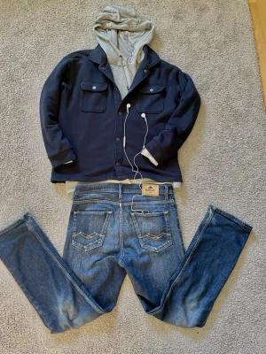 Blå jeans från Replay - Säljer ett par klassiska blå jeans från Replay med raka ben och snygga kontrastsömmar på bakfickorna. Jeansen har normal midja och femficksmodell. Perfekta till en laidback stil och passar till det mesta i garderoben. Storlek = 14A vilket motsvarar W27 L29 i herr jeans.