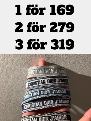 Christian Dior J'Adior tygarmband - Säljer flera Christian Dior J'Adior armband i olika nyanser av blått, grått och vitt. Armbanden är gjorda i tyg med broderad text och har justerbar knytning. Perfekt accessoar för att lyfta din outfit med en lyxig touch.