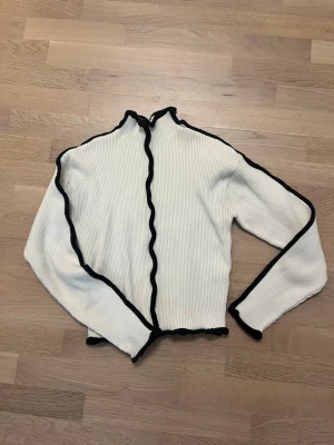 Tröja polokrage tröja NA-KD - En polotröja från NA-KD i storlek S.  Lite av den svarta kanten har lossnat på höger sida (ses på bild 3). Enstaka noppror (bild 6) Material: 53% polyester, 36% viskos, 11% polyamids.
