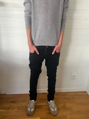 Svarta slim fit jeans W27 L32 - Säljer ett par svarta slim fit jeans med klassisk femficksmodell och normal midja. Jeansen har smal passform hela vägen ner och är perfekta för en clean och stilren look. Materialet är mjukt och stretchigt för extra komfort. 🙌🙌