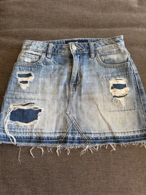 Blå jeanskjol med slitningar - Så snygg jeanskjol från hollister med hål! Storlek 0, 24w. Fint skick!