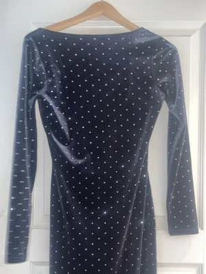 Svart klänning med strass från HM - En svart klänning i fejk krossat sammet med strass. Från Hm. Perfekt till t.ex. en nyårsfest! 🚨Tar bara emot betalningar via Swish!!! Om du vill ha fler bilder eller har frågor är det bara att skriva till mig!!!🚨