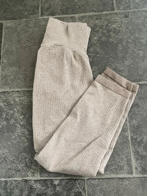 Beige ribbade Aim’n trekvarts  - Snygga beige Aim’n träningstights med ribbad struktur och hög midja. Tightsen är stretchiga och sitter skönt på kroppen, perfekta för gymmet eller yoga. Materialet är mjukt och följsamt, vilket ger bra rörelsefrihet.