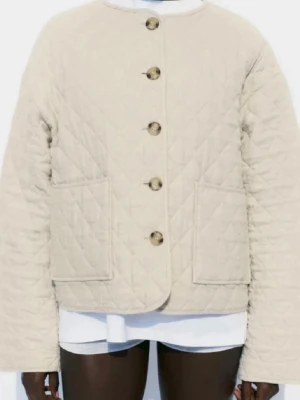 Beige quiltad cardiganjacka - Stilren beige quiltad cardiganjacka med rund halsringning och stora knappar framtill. Jackan har två rymliga framfickor och raka ärmar. Perfekt för lager på lager och ger en trendig look till din outfit.