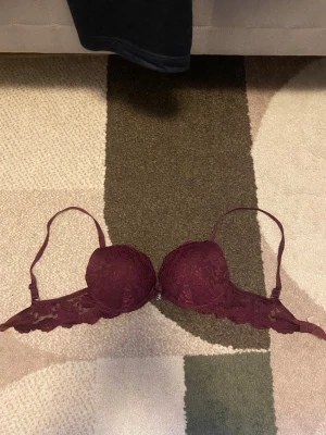 Vinröd spets-bh  - Snygg vinröd bh med lite push-up. I storlek 70B men passar mig som har 75A