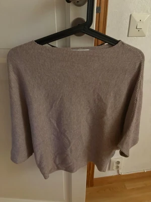 Beige top från JDY - Beige stickad topp från JDY i storlek XS. Toppen har rund hals, trekvartsärm och loose passform. Materialet är mjukt och lätt ribbat vilket ger en chill vibe. Perfekt för lager på lager under vår och höst. Storlek XS men kan passa som S