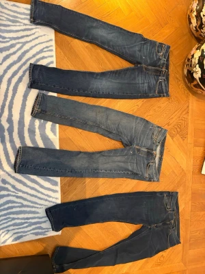 Mörkblå slim fit jeans från nudie  - Säljer tre par jeans från märket nudie i passformen lean Dean. Dem två till höger är strlk 29/30 och den längst till vänster har strlk 28/32. Två av jeansen har dessvärre hål i fickan men skall vara enkelt att laga dö man får gratis lagning hos nudiebutiken. Jag säljer alla tre för 700 kr. 