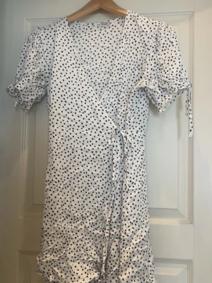 Vit prickig omlottklänning från Pimkie - Vit prickig omlottklänning från Pimkie. Small/Medium. 🚨Tar bara emot betalningar via Swish!!! Om du vill ha fler bilder eller har frågor är det bara att skriva till mig!!!🚨