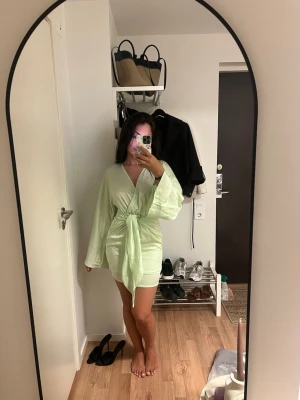 Ljusgrön omlottklänning med knyt - Säljer min mintfärgade klänning från Gina tricot. Helt oanvänd med prislapp kvar.  