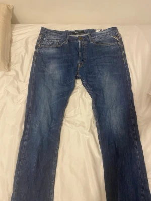 Blå replay jeans  - Säljer ett par klassiska blå jeans med raka ben och snygga slitningar. Jeansen har fem fickor, knappgylf och är tillverkade i bomull för en skön känsla. Perfekta för dig som gillar en avslappnad och tidlös stil i storlek pris går att diskutera 😁