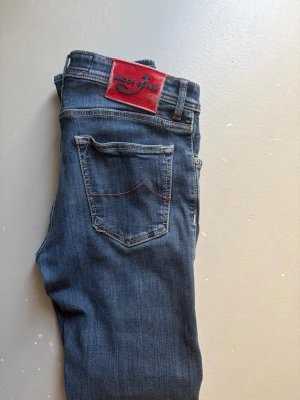 Jacob Cohen Jeans - Säljer nu dessa Choens med riktigt snygga röda detaljer runt byxorna, Storlek 33, hör av dig vid mer frågor.
