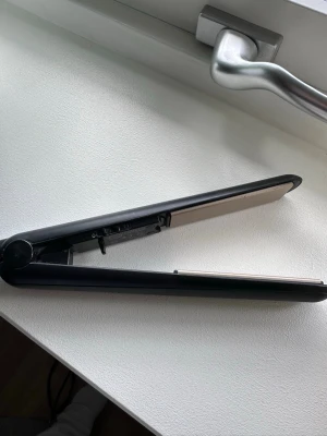 Svart plattång Philips - Säljer en svart plattång från Philips, modell StraightCare Essential. Plattången har keramiska plattor och en smidig, avlång form som gör den enkel att använda. Perfekt för att styla håret snabbt och smidigt hemma.