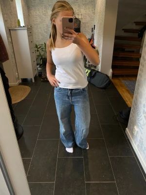 Blå raka jeans med hög midja - Säljer ett par klassiska blå jeans med rak passform och hög midja men jag har haft de lågmidjade för att få de baggy! Jeansen har fyra fickor och stängs med dragkedja och knapp. Perfekta till vardags och passar till det mesta. Materialet är denim i bomull och färgen är ljusblå.