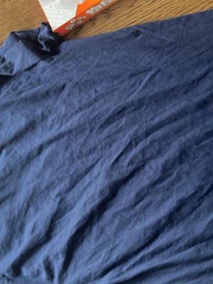 Mörkblå t-shirt med tryck - Mörkblå t-shirt i bomull med gult tryck på ryggen där det står 'Stoppa sosseriet'. Klassisk passform och rund halsringning. Perfekt för dig som vill sticka ut med ett statement-plagg.