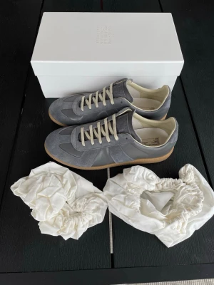 Margiela GATS | Grå - Säljer ett par stilrena Maison Margiela gats i färgen grå. | Storlek: 44 | Skick: 9.5/10, endast använda fåtal gånger | Kommer komplett med box och dustbags | Skickas samma dag som köp, och paketet packas noggrant för att säkerställa att varan kommer fram i bästa skick. | Pris: 3299kr, går att diskuteras vid snabb affär. | PM vid frågor om pris, eller andra frågor om varan. // William