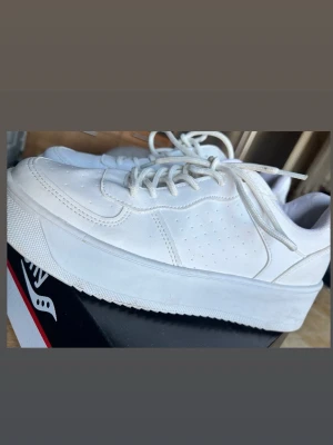Vita chunky sneakers med platåsula - Säljer ett par helvita sneakers med chunky platåsula. Skorna har klassisk snörning och är tillverkade i ett slätt material som liknar läder. Perfekta för dig som gillar en clean och modern stil.