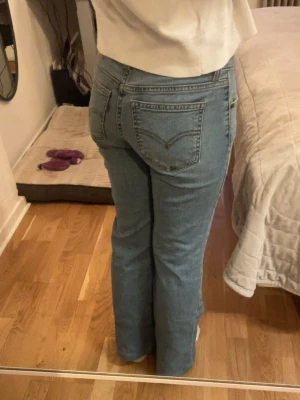 Ljusblå Levi's jeans med raka ben - Säljer ett par klassiska ljusblå lowwaist jeans från Levi's med raka, utsvängda ben och femficksmodell. Jeansen har Levi's ikoniska läderpatch bak i midjan och röda logotag på bakfickan. Perfekta till en avslappnad stil och passar till det mesta.