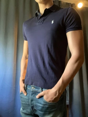 Ralph Lauren piké  - Svart Ralph Lauren piké!                                Storlek: S                                                             Färg: Svart med vit logga                                  Skick: 9/10                                                       Nypris: Runt 1300kr                                                    Hör av er vid frågor o funderingar!