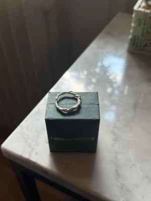 Silvrig ring med tvinnad design - Unik silvrig ring med tvinnad och knutliknande design. Köpt på en fransk smyckesbutik i Paris så går inte att få tag i. I nyskick. Smyckespåse ingår💗💗