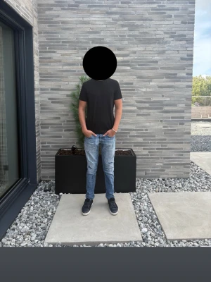 Dondup jeans  - Dondup George jeans i ljusblå tvätt med snygg distressed/sliten look. Personen som bär byxorna är 192 cm lång och väger ca 80 kg. Fint begagnat skick med slitningar och hål som är en del av modellen. Nypris ca 3 600 kr.