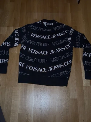 Svart sweatshirt - Svart sweatshirt med vit text över hela tröjan
