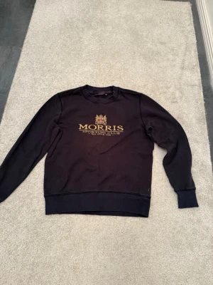 Morris  Sweatshirt / Crewneck – Svart (Stl S) - Snygg svart tröja från Morris Stockholm med guldigt "Sporting Club"-tryck på bröstet. Sitter riktigt snyggt och passar till det mesta. 