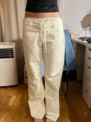 Vida vita jeans med snörning fram - Säljer ett par vita jeans med rak passform och snörning i midjan istället för dragkedja. Köpta på Zara i storlek M men insydda på båda sidorna. Uppskattar en stor S. Använda fåtal gånger då det är för stora.