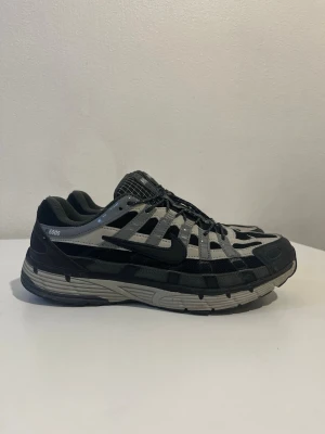 Nike p-6000 grå svart  - Nike sneakers i grått och svart med sportig design och tydliga paneler. Använt i 2 månader men blivit för små inget fel på de, storlek 43