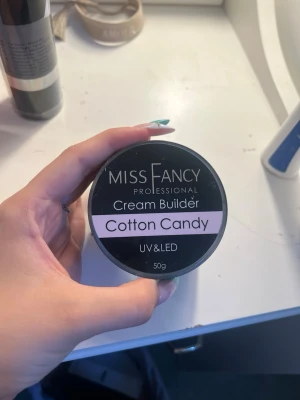 Miss Fancy Cream Builder Cotton Candy - Miss Fancy Professional Cream Builder i färgen Cotton Candy är en UV/LED-härdande nagelgel på 50g. Gelen har en mjuk, ljusrosa ton och krämig konsistens som gör det enkelt att bygga snygga naglar. Perfekt för dig som vill skapa egna nagelförlängningar eller förstärkningar.