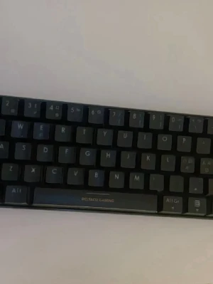 Deltaco Gaming kompakt tangentbord - Säljer ett svart kompakt tangentbord från Deltaco Gaming. Tangentbordet har en minimalistisk design med tydliga vita tecken på knapparna och ansluts med kabel. Perfekt för gaming eller studier där du vill spara plats på skrivbordet. Säljer razer mus och deltagit gaming tangentbord och den under  svart vit färg , säljer då inte spelar spel längre och vill bli av med det