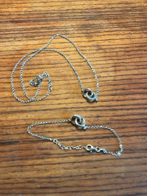 Silverfärgat halsband med dropphänge - Säljer ett stilrent halsband i silverfärg med ett droppformat hänge. Kedjan är tunn och elegant, perfekt för att ge en minimalistisk touch till din outfit. Passar dig som gillar enkla men snygga accessoarer.