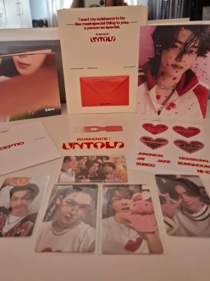 Romance: Untold K-pop photopaket - Säljer ett K-pop photopaket 'Romance: Untold' med flera fotokort, vykort, klistermärken och ett häfte. Färgerna går i rött, vitt och rosa med olika motiv på medlemmar. Perfekt för samlare eller fans av K-pop och idolgrupper.