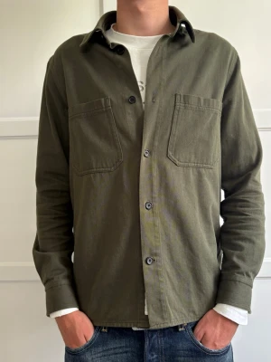 Grön Overshirt - Tjena! Jag säljer nu min snygga overshirt från Arket. Storleken är 48. Modellen på bilden är 185 lång, så passar dig som är ungefär den längden. Nypris 790, mitt pris 350. Hör av dig om du har någon fråga!