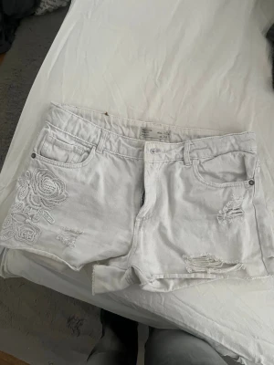 Vita denimshorts med broderi - Säljer ett par vita denimshorts. Storlek 164 är från Zara girls collection. Säljer pågrund av att ja inte kan ha de längre.
