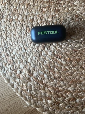 Festool svarta trådlösa in-ear hörlurar - Säljer ett par svarta trådlösa in-ear hörlurar från Festool. Hörlurarna kommer i ett smidigt laddningsetui med Festool-logga i grönt. Perfekta för dig som vill ha bra ljud och enkel användning. Snygg och kompakt design.